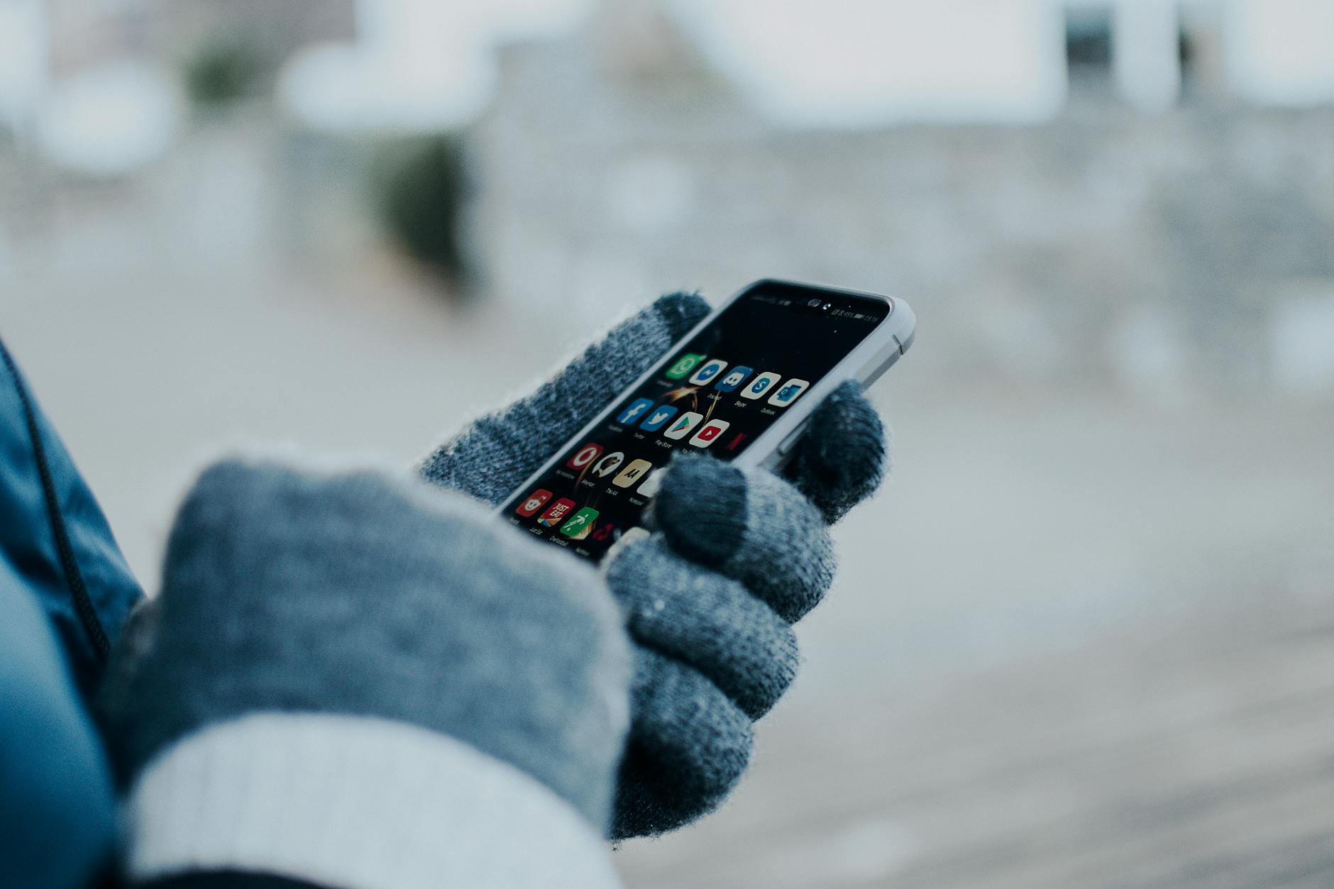 person wearing gloves holding a cellphone